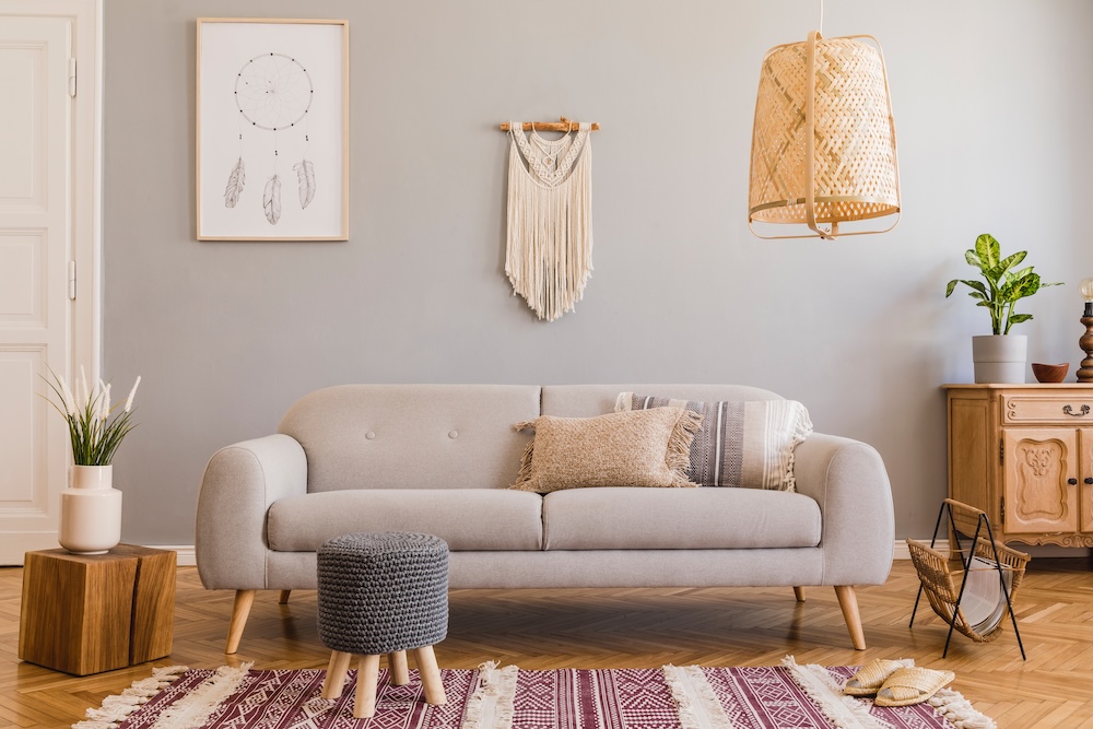 salon z naturalnymi dodatkami - makrama i lampa z abażurem na suficie salon z szarymi ścianami i sofą w stylu boho