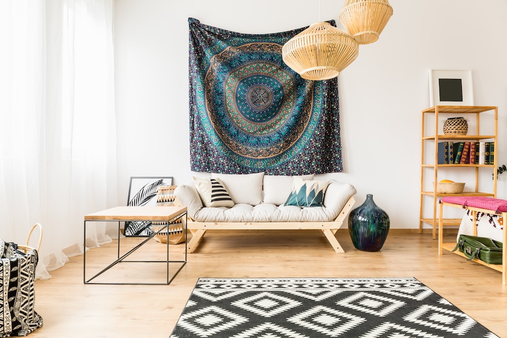 salon w stylu boho z sofą i materiałem na ścianie salon w stylu naturalnym z drewnianymi meblami i dywanem w czarno-białe wzory