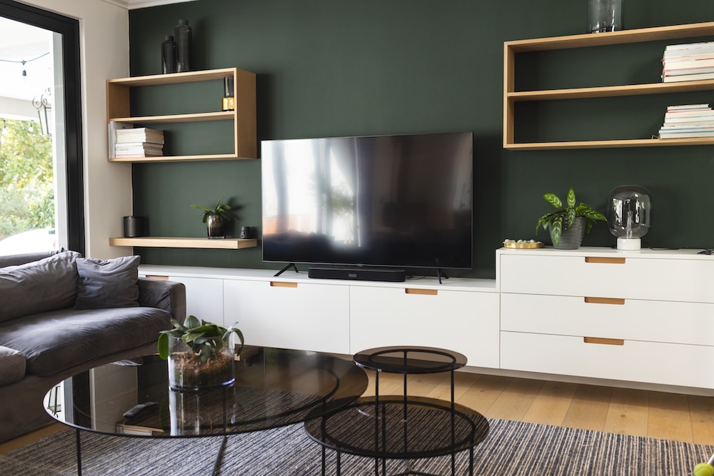 ściana z tv w salonie z meblościanką z białymi frontami i półkami 